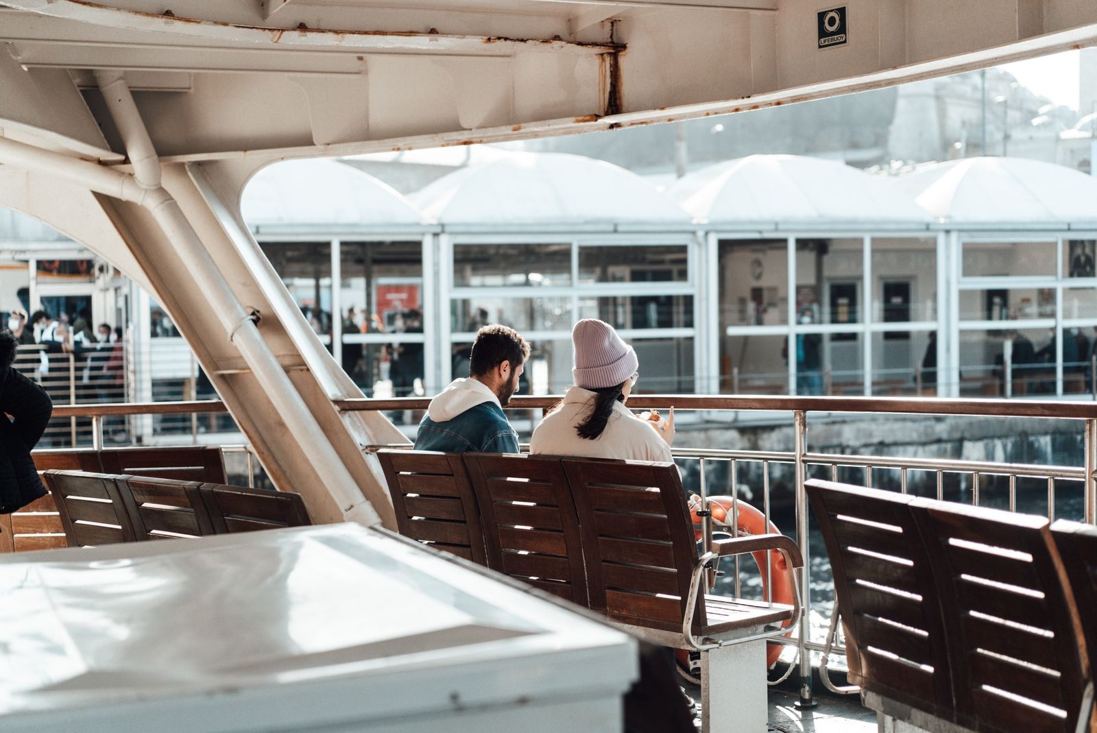 Travelers relaxing on benches on a ship deck, the everyday scene for discount cruisers