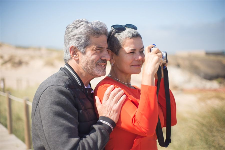 Older couple taking a photo together outdoors