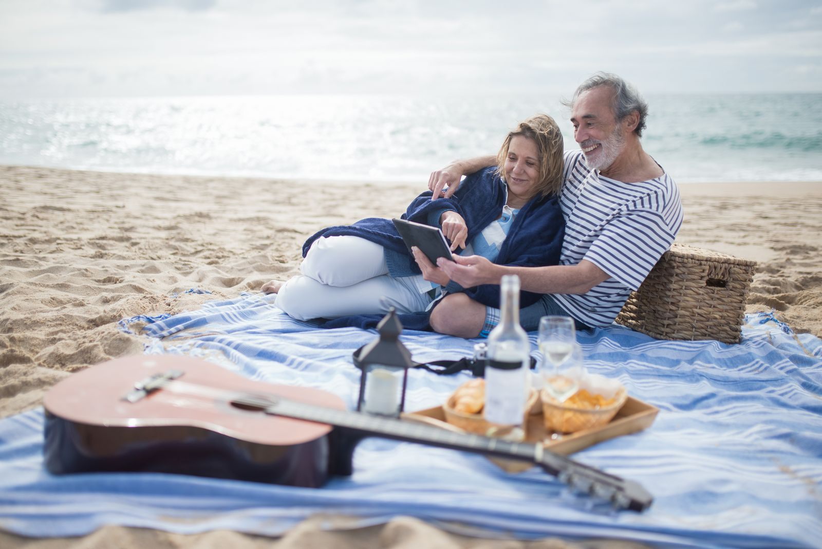 Older couple relaxing on a beach blanket, the travelers who find discount cruises for seniors