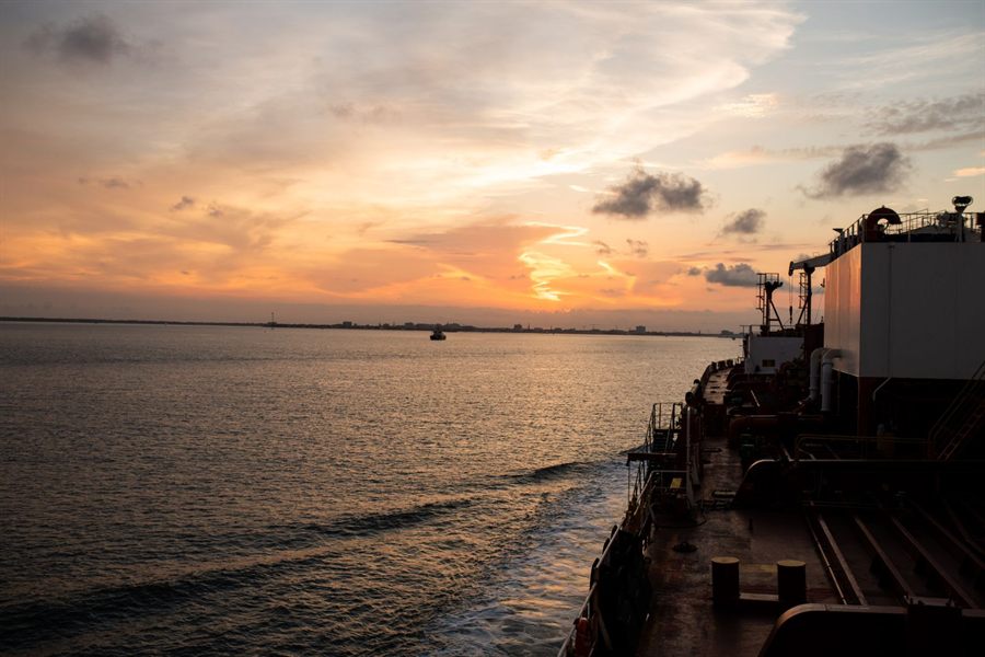 Sunset over the sea from the deck of a moving ship